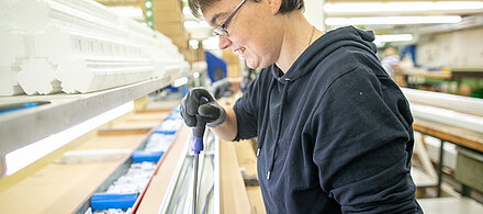 Person steht an Werkbank